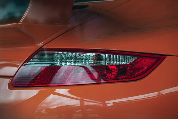 Zbliżenie Reflektora Nowoczesnego Pomarańczowego Samochodu Sportowego — Zdjęcie stockowe
