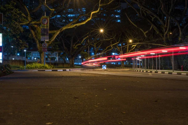 Uma Estrada Cidade Que Enrola Através Das Árvores Escuro Exposição — Fotografia de Stock