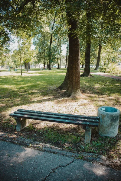 公園内のベンチとコンクリートのゴミ箱の垂直ショット — ストック写真