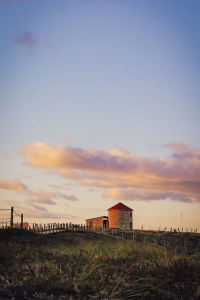 在多云的天空下 一个有风车塔和小农舍的绿地的垂直拍摄 — 图库照片