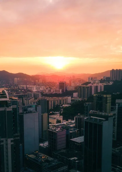 Вертикальний Знімок Хмарочосів Оточений Пагорбами Під Час Заходу Сонця Гонконзі — стокове фото