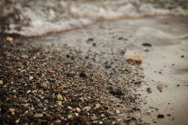 Una Macro Toma Los Pequeños Guijarros Playa Arena Mojada Siendo —  Fotos de Stock