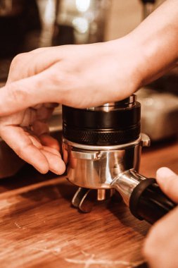Kahve yapan bir baristanın dikey yakın çekimi.