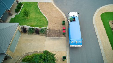 Bir banliyöde çöpleri toplayan bir çöp kamyonunun hava görüntüsü.