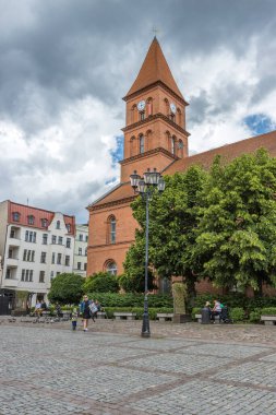 Polonya 'nın Torun kentindeki Kutsal Üçleme Kilisesi' nin önündeki güzel parkın dikey görüntüsü.