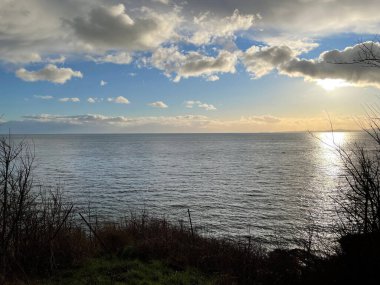 Gün doğumunda huzurlu gölün üzerinde beyaz kabarık bulutlar