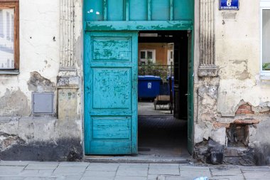 Açık mavi ahşap kapısı olan eski bir binanın dış görünüşü.