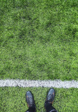 Spor sahasında çimlerin üzerinde duran bir adamın yakın plan fotoğrafı.