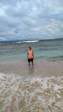 Filipinler 'de mavi bulutlu gökyüzünün altında eğlenen bir erkeğin görüntüsü.