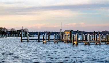 Bulutlu bir gökyüzünün altında, göle demirleyen boş tekne.