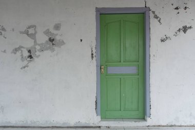 Indramayu 'da beyaz bir duvardaki yeşil kapının güzel bir görüntüsü.
