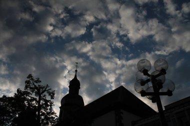 Bulutlu bir geçmişi olan bir kilise kulesi.