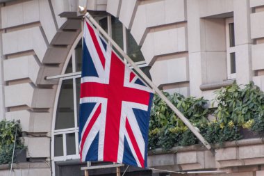 Büyük Britanya bayrağının bir binanın arka planındaki yakın plan resmi.
