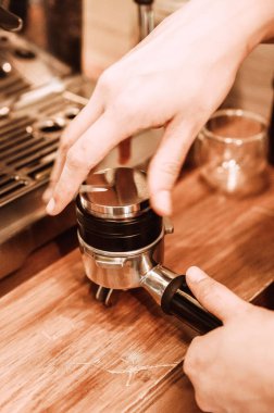 Kahve yapan bir baristanın dikey yakın çekimi.