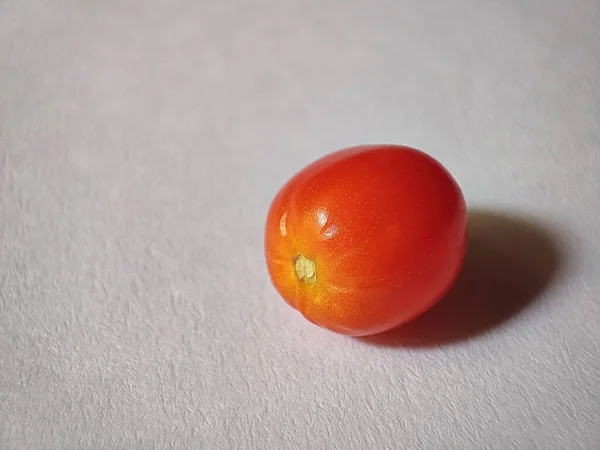 Eine Nahaufnahme Einer Roten Mini Kirschtomate Auf Einer Weißen Oberfläche — Stockfoto