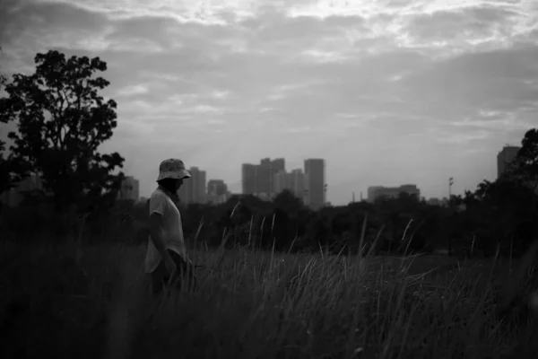Серый Цвет Женщины Шляпе Прогуливающейся Траве Недалеко Города — стоковое фото
