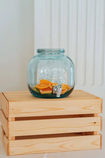 Pionowe Ujęcie Słoika Lemoniadą Plasterkami Owoców Środku Drewnianej Skrzyni Białym — Zdjęcie stockowe