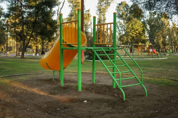 Public park with games for children. Safe slide in the foreground.