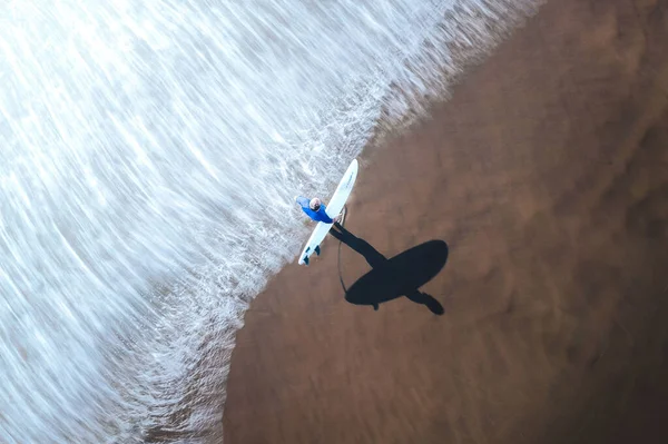 Вид Сверху Воздуха Серфингиста Идущего Песчаному Пляжу Против Моря Держащего — стоковое фото