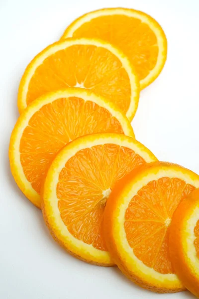 白い背景にオレンジのスライスの垂直クローズアップショット — ストック写真