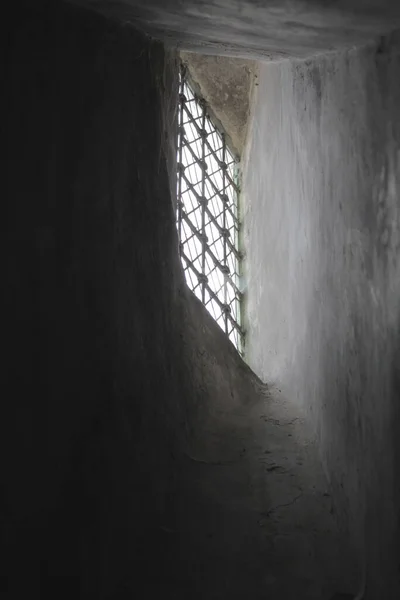 Ein Vertikaler Lichtstrahl Der Durch Ein Steinernes Gitterfenster Einem Verlies — Stockfoto