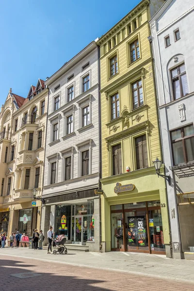 在波兰托伦的传统建筑下 人们走在商店前面的垂直镜头 — 图库照片