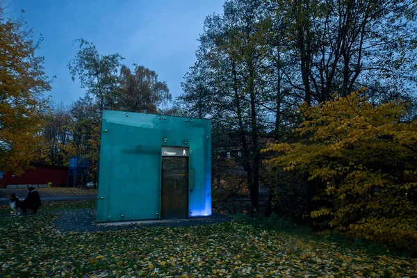 秋天公园里的一个玻璃管现代公共厕所 — 图库照片