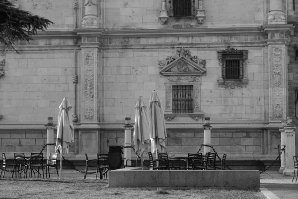 Grayscale Shot Chairs Tables Umbrellas Front Restaurant Alcala Henares Spain — Stock Photo, Image