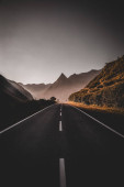 Картина, постер, плакат, фотообои "a vertical shot of an asphalt road with rocky mountains in the background in a rural area", артикул 576630840