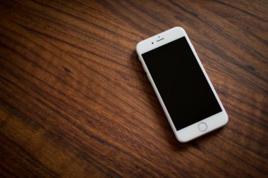 Ahşap bir yüzeyde kilitli bir akıllı telefonun üst görüntüsü. Reklamınız için iyi bir fikir.