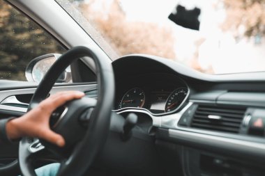 Bir arabanın direksiyonundaki elin yakın çekimi.