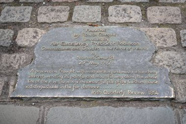 Rowan Gillespie 'nin 1997' de Dublin Rıhtımı 'nda açılışı yapılan Kıtlık Heykeli' yle ilgili yazıyla bronz tabak.