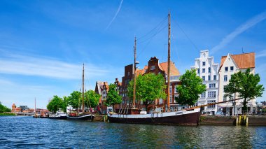 Eski Luebeck kasabasındaki ticaret evlerini gören yelkenli gemilerin manzarası.