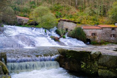 Eski su değirmenleriyle Barosa Nehri 'nin büyük akışına sahip bir şelale. Galiçya - İspanya