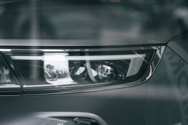 Gri bir arabanın farının yakın çekimi.