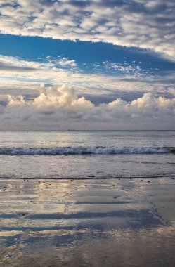 İngiltere 'nin Wight Adası' ndaki mavi bulutlu gökyüzüne karşı güzel bir sahilin dikey görüntüsü.