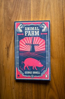 Calgary, Alberta - 23 Mayıs 2022: George Orwell 'in ahşap arka plandaki Hayvan Çiftliği romanı.