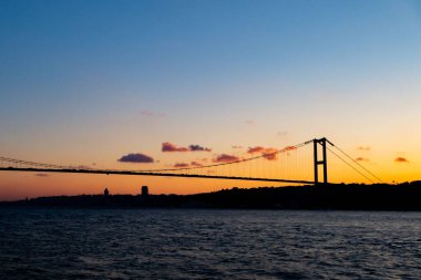 İstanbul, Türkiye 'de gün batımında bir köprünün siluetinin uzaktan görünüşü