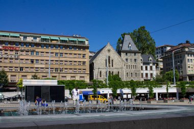 Bir çeşme ve Place de la Riponne, Cenevre, İsviçre 'deki tarihi binalar.