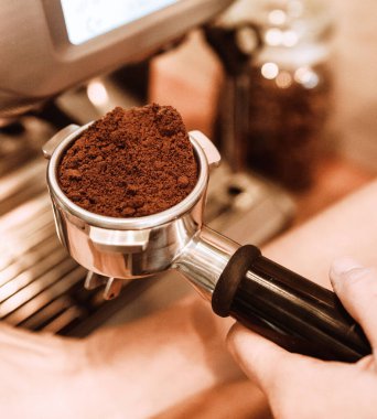 Kahve makinesinde kahve yapan bir baristanın yakın çekimi.