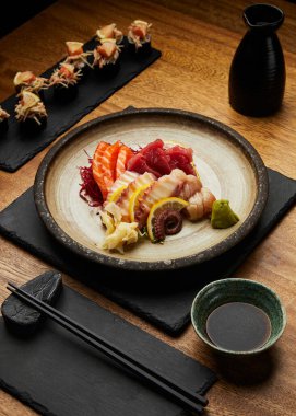 Tabakta soya sosu, wasabi ve çubuk ile farklı suşi türlerinin dikey yakın çekimi..