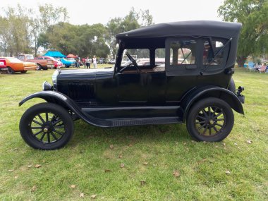 Kırsal alanda eski siyah Ford Model T Fordor Phaeton 1926. Doğa yeşili çimenler ve ağaçlar. Klasik araba şovu. Kopyalama alanı