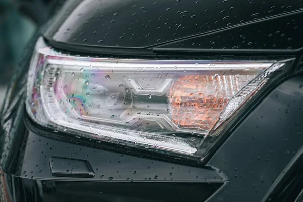 黑色汽车前灯的特写 带有新鲜雨滴 — 图库照片