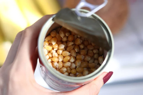 用一个女人的手指拿着一罐开着的玉米粒进行选择性的聚焦拍摄 — 图库照片