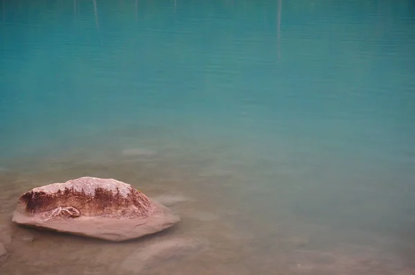 ターコイズブルーの湖の岸にピンクの石灰岩の石 — ストック写真