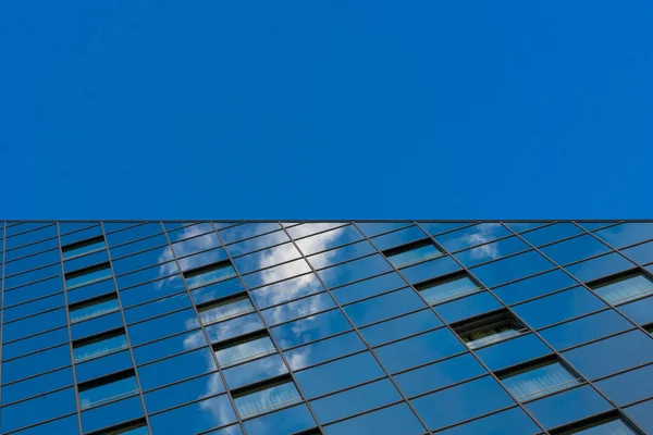 Niski Kąt Ujęcia Nowoczesnego Budynku Lustrzanymi Oknami Odbitymi Chmurami Pod — Zdjęcie stockowe