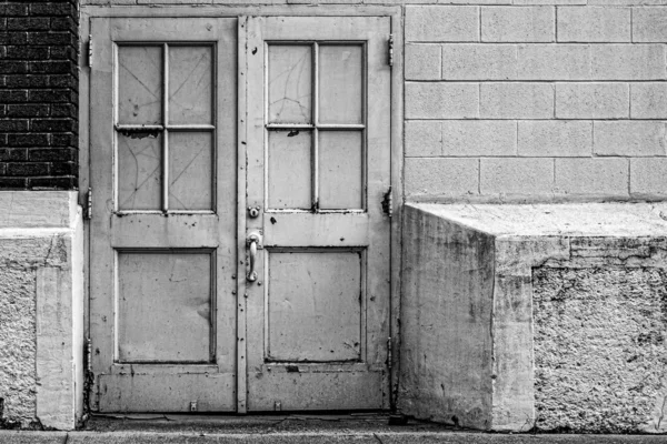 Eski kapalı bir kapının gri tonlu bir görüntüsü.