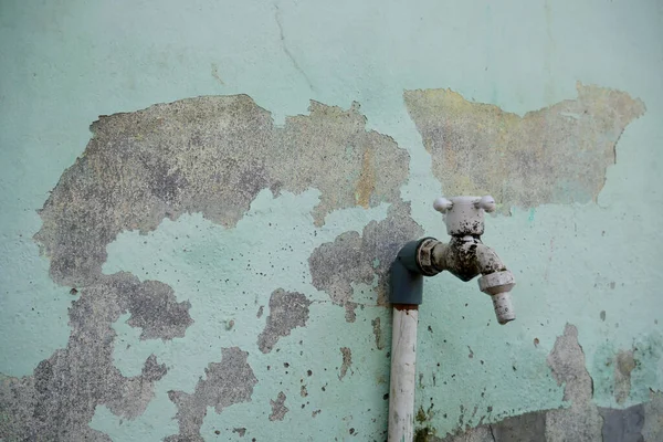 壁に貼られたパイプに接続されている古い素朴な水の蛇口 — ストック写真