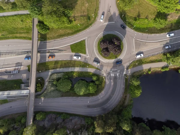 Bird\'s eye view of a traffic roundabout, roads, lanes with cars in Partille.  Aerial, drone photography taken from above in Sweden in summer.