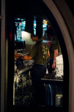 Bir bardak bira dolduran bir barmenin dikey çekimi. Bardaki bar tezgahı..